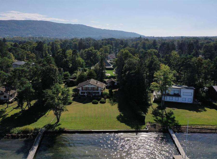 Lakefront property with stunning mountain views and expansive lawns.