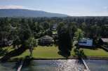 Lakefront property with stunning mountain views and expansive lawns.