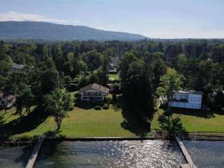 Lakefront property with stunning mountain views and expansive lawns.