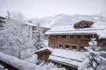Nestled in a snowy landscape, this stunning property showcases a charming wooden exterior and a cozy atmosphere.