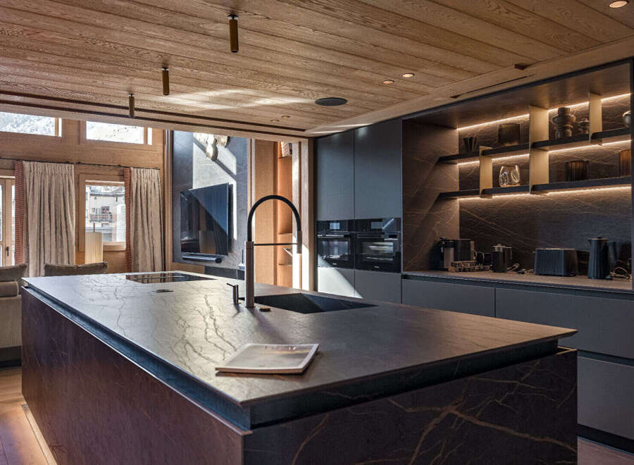 Experience luxury living in this stunning kitchen, featuring a sleek island with a modern faucet and sink.