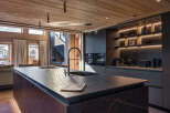 Experience luxury living in this stunning kitchen, featuring a sleek island with a modern faucet and sink.