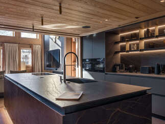 Experience luxury living in this stunning kitchen, featuring a sleek island with a modern faucet and sink.
