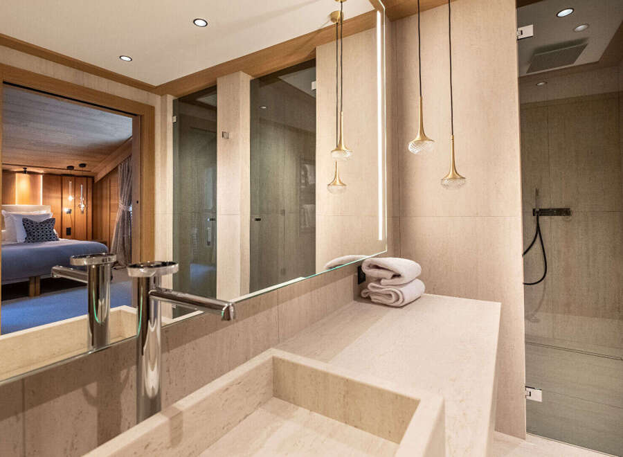 Experience luxury in this stunning bathroom, featuring a sleek sink, elegant lighting, and a spacious shower.