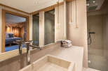 Experience luxury in this stunning bathroom, featuring a sleek sink, elegant lighting, and a spacious shower.