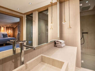 Experience luxury in this stunning bathroom, featuring a sleek sink, elegant lighting, and a spacious shower.