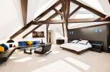 Experience luxury living in this stunning attic bedroom featuring a spacious king-size bed with a modern dark wood headboard and integrated lighting.