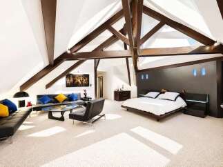 Experience luxury living in this stunning attic bedroom featuring a spacious king-size bed with a modern dark wood headboard and integrated lighting.