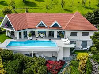 Experience luxury living in this stunning modern villa, featuring a breathtaking infinity pool overlooking lush green hills.