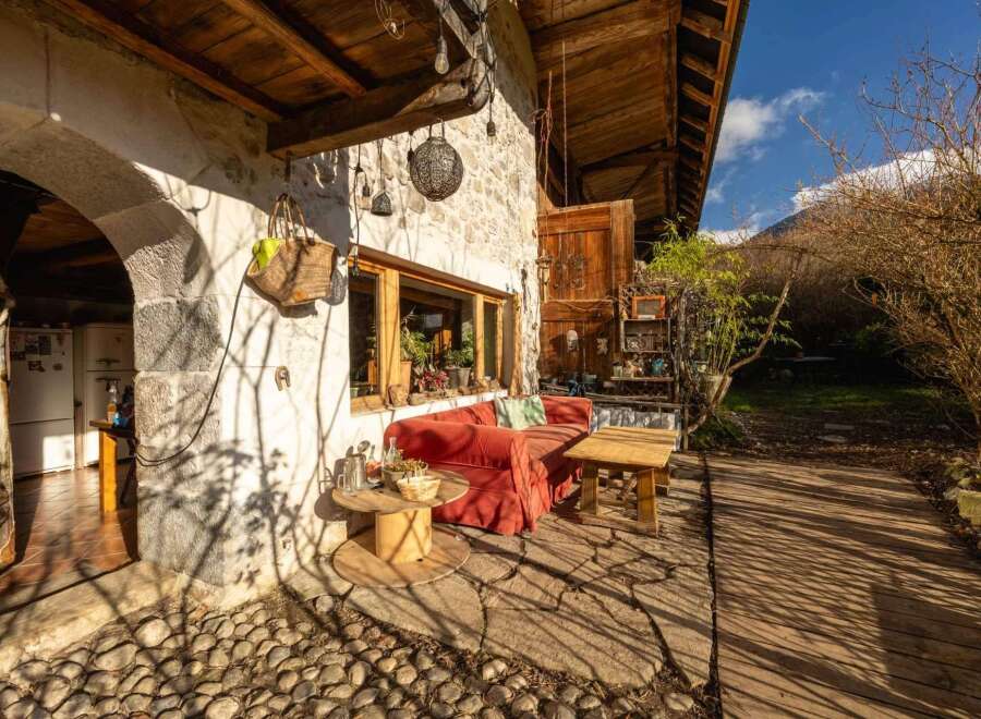 Rustic stone house with charming outdoor patio, perfect for relaxing and enjoying the mountain views.