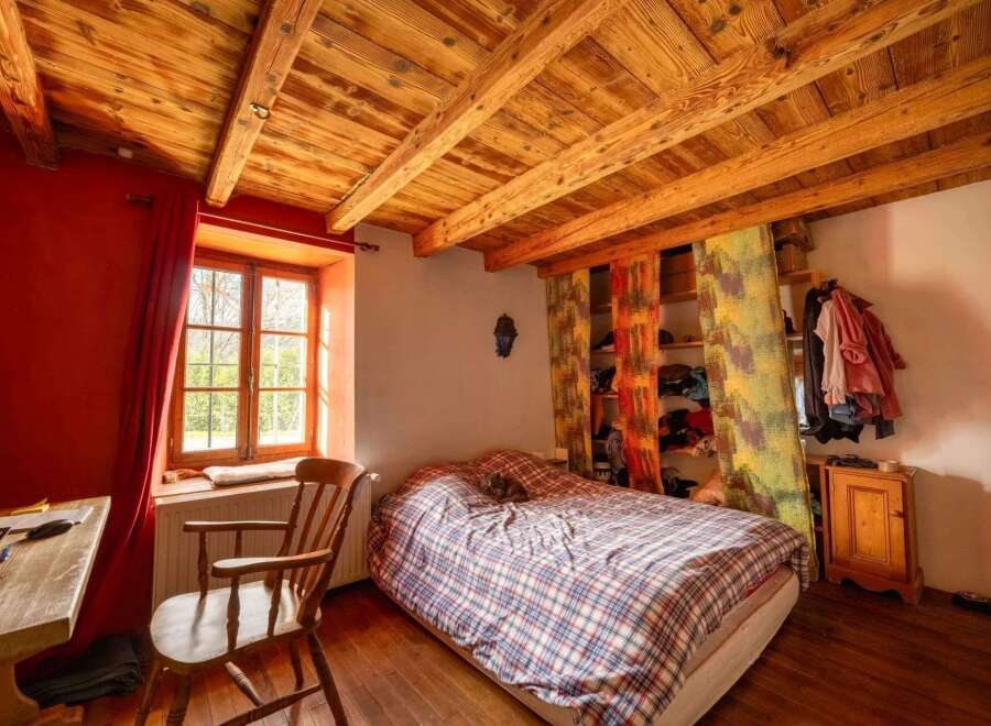 Charming bedroom with exposed wooden beams and a cozy atmosphere.