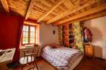 Charming bedroom with exposed wooden beams and a cozy atmosphere.