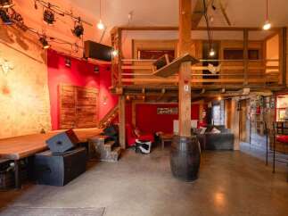 Rustic-chic venue with a stage, lofted area, and exposed beams.