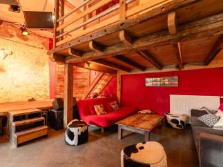 Rustic-chic barn conversion with exposed beams and a mezzanine level.