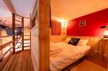 Cozy cabin bedroom with a unique wooden design and a comfortable bed.