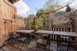 Enjoy al fresco dining on this charming patio, featuring rustic wooden tables and chairs repurposed from vintage sewing machines.
