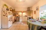 Charming kitchen with tiled floors and walls, featuring white cabinets and appliances.