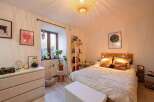 Cozy bedroom with a pallet bed, soft textiles, and plenty of natural light.