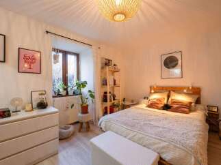 Cozy bedroom with a pallet bed, soft textiles, and plenty of natural light.