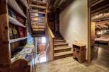 Rustic wooden chalet with charming wooden staircase and built-in bookshelf.
