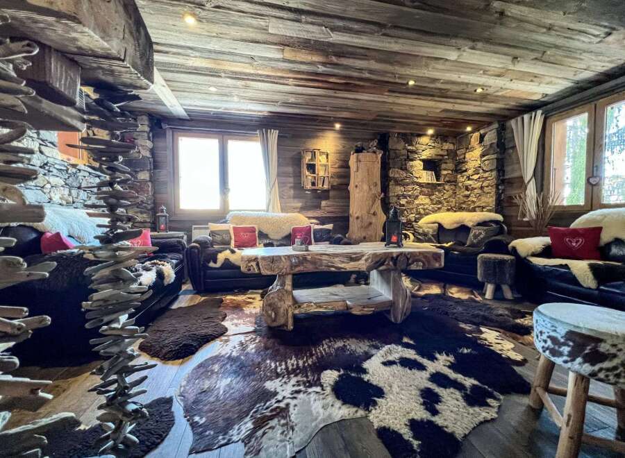 Rustic mountain chalet with wood-paneled ceilings and stone walls.