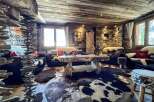 Rustic mountain chalet with wood-paneled ceilings and stone walls.