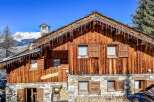 This charming chalet boasts a rustic wooden exterior with stone accents, creating a cozy and inviting atmosphere.
