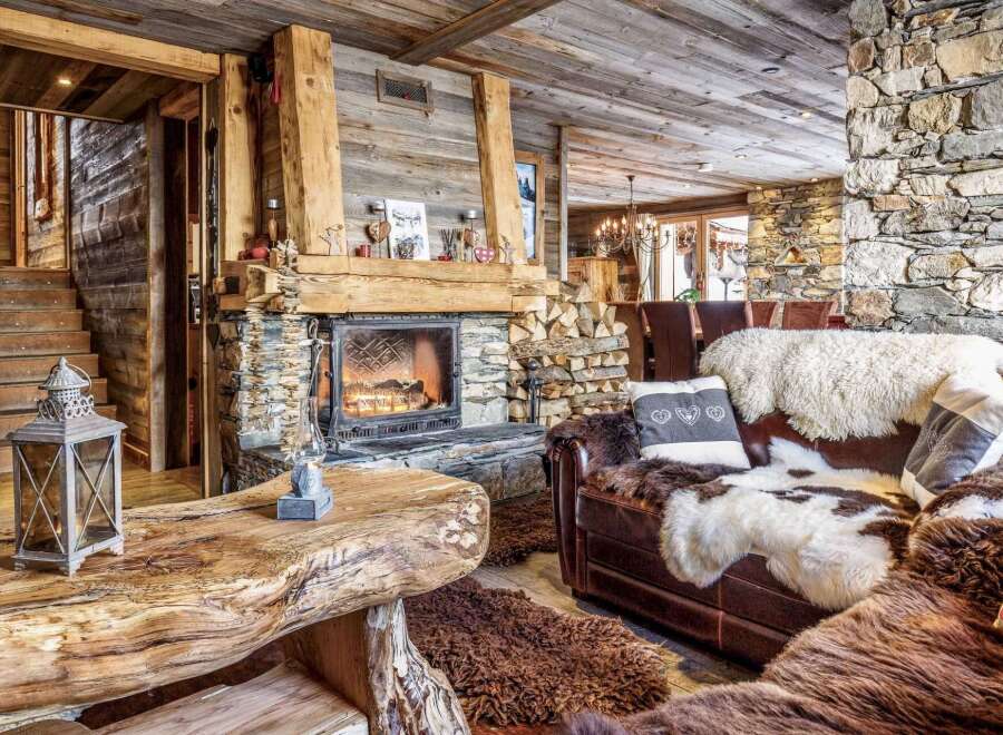 Cozy up by the fireplace in this stunning chalet, featuring rustic wood and stone finishes.