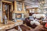 Cozy up by the fireplace in this stunning chalet, featuring rustic wood and stone finishes.