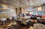 This stunning chalet boasts a rustic-chic interior with exposed wood beams, a stone fireplace, and luxurious cowhide rugs.
