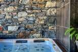 Indulge in ultimate relaxation in this luxurious hot tub, nestled against a stunning stone wall.
