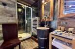 Rustic-chic bathroom with a walk-in shower, stylish stone sink, and wooden accents.