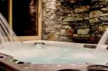 Luxury chalet with a private hot tub nestled against a stunning stone wall.