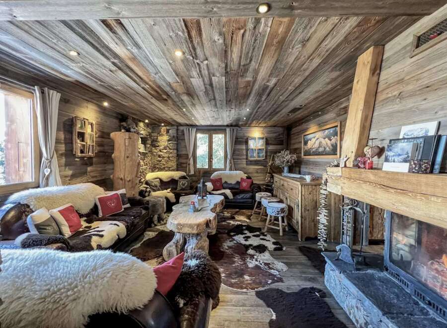 This stunning chalet boasts a rustic-chic interior with exposed wood beams, a cozy fireplace, and luxurious cowhide rugs.