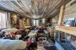 This stunning chalet boasts a rustic-chic interior with exposed wood beams, a cozy fireplace, and luxurious cowhide rugs.