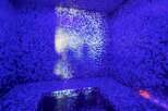 Indulge in tranquility within this stunning steam room, featuring a captivating mosaic tile design and soothing purple LED lighting.