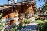 This charming chalet boasts a rustic wooden exterior with stone accents, creating a cozy and inviting atmosphere.