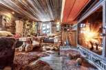 Cozy up by the fireplace in this rustic chalet, featuring a wood-burning stove and stunning mountain views.