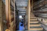 Rustic mountain home with stunning wood-paneled staircase and cozy cowhide rugs.