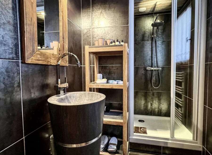 Luxurious bathroom with a unique stone sink and wooden accents.