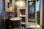 Luxurious bathroom with a unique stone sink and wooden accents.
