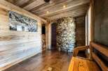 This luxurious chalet boasts a stunning spa area, complete with a rustic stone shower and a relaxing wooden bench.