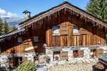 This charming chalet boasts a rustic wooden exterior with stone accents, creating a cozy and inviting atmosphere.