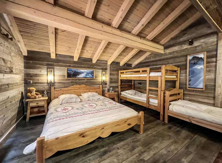 Cozy chalet bedroom with wooden beams, rustic decor, and a double bed.