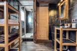 This luxurious bathroom boasts a spacious shower, sleek dark tile, and rich wood accents throughout.