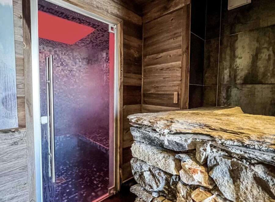 Luxurious chalet sauna with stunning wood and stone finishes.