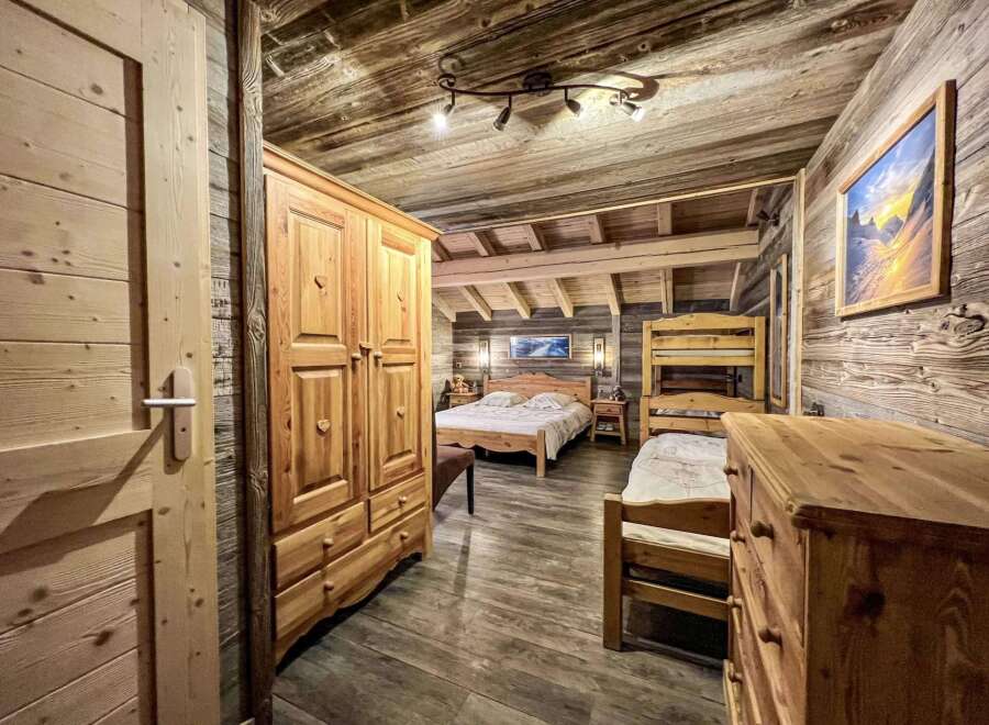 Rustic wooden chalet bedroom with stunning mountain views.