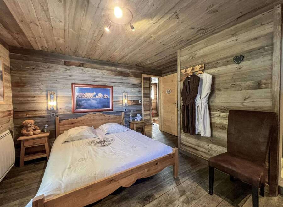 Cozy wooden cabin bedroom with a comfy double bed, plush bathrobes, and a rustic feel.