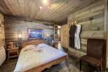 Cozy wooden cabin bedroom with a comfy double bed, plush bathrobes, and a rustic feel.