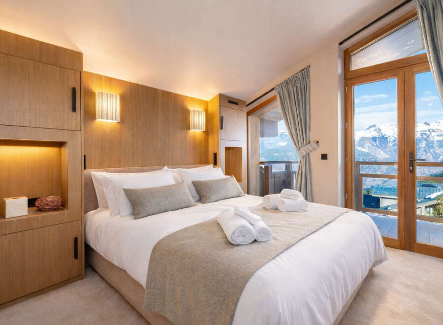 Experience luxury living in this stunning bedroom with breathtaking mountain views.
